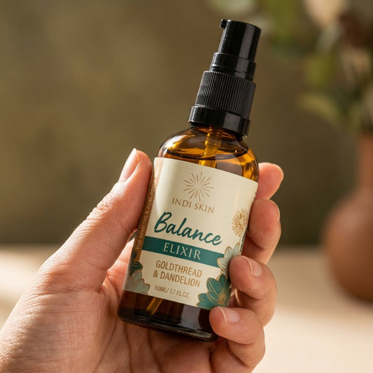 A dynamic, close-up macro shot of the 'Balance Elixir with Goldthread & Dandelion' bottle held gentl