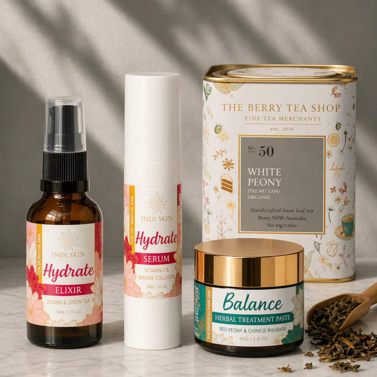 Indi Skin Hydrate and Balance products alongside loose leaf white peony tea