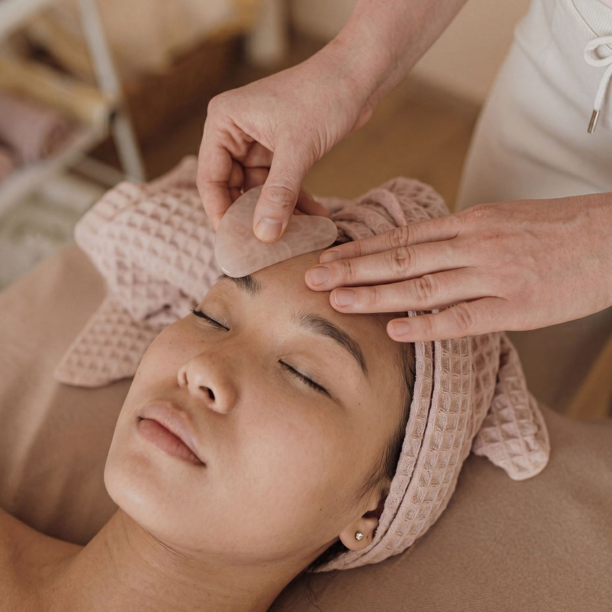 Traditional Chinese medicine facial treatment applied to a client's forehead